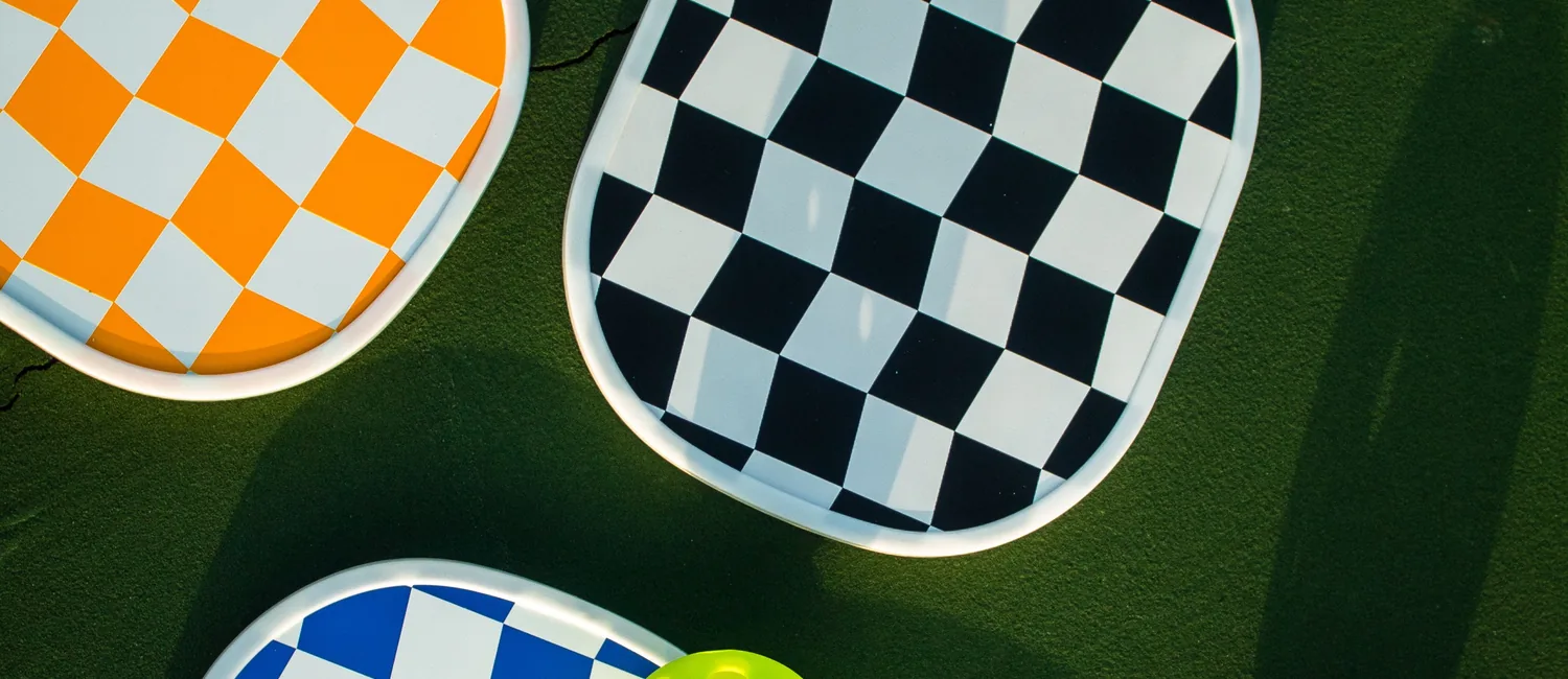 Colorful pickleball paddles and balls arranged on a court